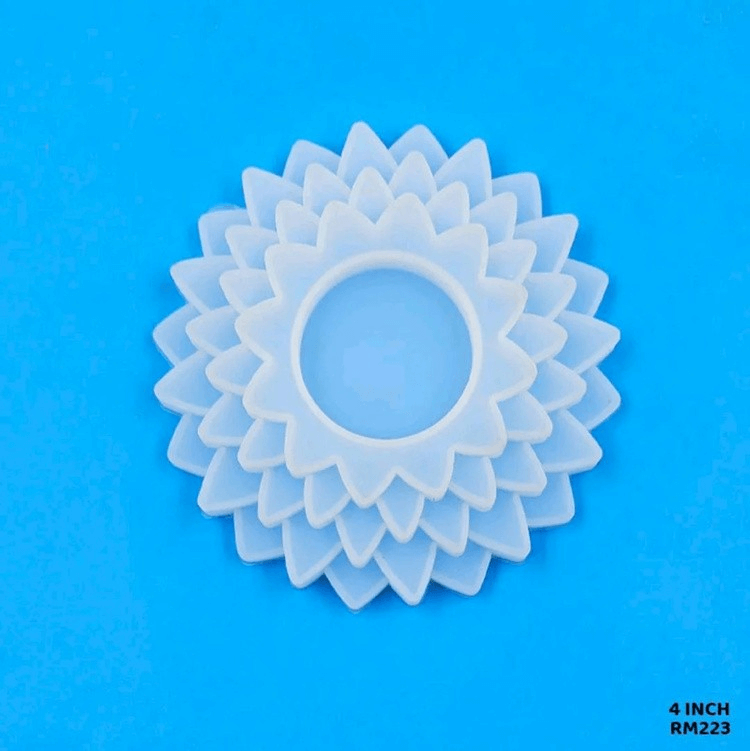 White translucent flower-shaped craft embellishment with layered petals and a central hole, placed on a blue background, labeled “4 INCH RM223.