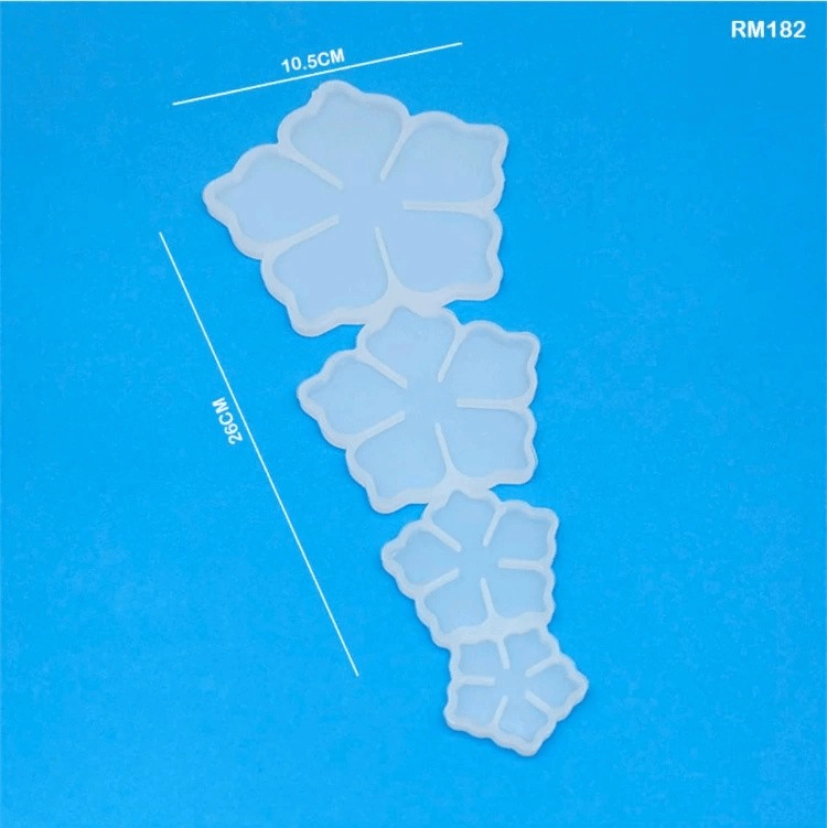 Four-flower silicone mold with petal design in translucent white, ideal for resin coasters, magnets, or DIY crafts on a blue background.
