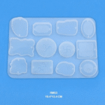Silicone mold with twelve symbolic cavities including Om, Swastika, geometric designs, and meditative figures, ideal for spiritual craft projects